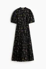 Vestido largo de algodón negro con estampado de flores pequeñas en tonos rosa y amarillo. Tiene cuello mao, mangas globo cortas, cinturón fino extraíble y falda acampanada con fruncido escalonado.