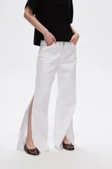 Pantalón de jean azul de tiro alto, corte recto y aberturas laterales en el ruedo.