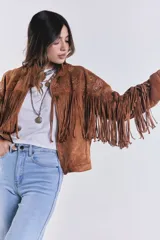 Campera marrón de gamuza con flecos y bordado de flores, con cierre cremallera y corte suelto.