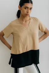 Remera blanca con corte horizontal y parte inferior negra. Cuello en V y mangas cortas.