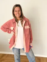 Sobrecamisa de pana texturada color rosa con detalles en tono más claro, corte oversize, bolsillos frontales aplicados y cierre frontal con botones.