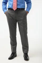 Ambo de vestir gris con saco de dos botones, solapa de muesca, dos bolsillos con solapa y un bolsillo de ojal en el pecho. Pantalón de vestir a juego, de corte recto.