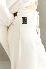 Jean de denim gris claro, de corte extra wide con pretina desflecada y bajo descosido.