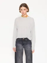 Sweater gris de tejido suave y flojo, largo a la primera cadera y mangas largas.