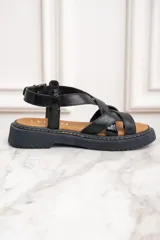 Sandalias de cuero negro con tiras cruzadas y hebilla al tobillo.