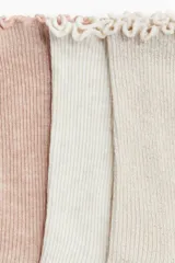 Pack de tres pares de medias de algodón acanalado en colores rosa, blanco y beige, con borde superior elástico y ribete sobrehilado.