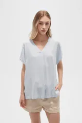 Blusa color beige de lino, holgada y con cuello en V.