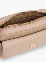 Bandolera Tommy Hilfiger color beige con correa ajustable y removible, compartimento principal con cierre de cremallera y logo monograma TH en la parte delantera.