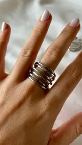 Anillo plateado de acero quirúrgico con diseño de múltiples aros finos.
