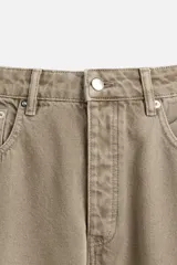 Pantalón cargo de denim color beige, corte relaxed fit, con bolsillos laterales tipo parche con solapa y cierre frontal con botones.