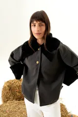 Sobrecamisa gris de paño de lana con cuello y puños de piel de cordero negra. Cierre frontal con botones dorados.