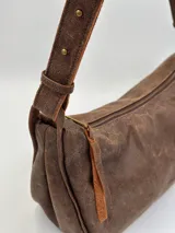 Cartera bandolera marrón de cuero con correa ajustable.