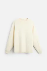 Sweater color crema de tejido suave, corte regular, cuello redondo y mangas largas con terminaciones en rib.