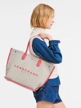 Bolso shopper Longchamp modelo Le Roseau Essential, tamaño L, color crudo con detalles en rojo y logo de jinete bordado.