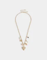Collar corto dorado con cadena de eslabones y dijes colgantes: corazón labrado, mariposa, perlas, cuentas de cerámica con flores y moño.