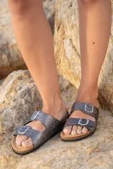 Sandalias blancas de cuero con doble tira y hebillas metálicas ajustables. Suela anatómica de corcho y goma.