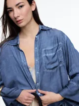 Camisa gris de manga larga confeccionada en viscosa teñida en frío, con efecto gastado. De corte relajado, con bolsillo delantero y puños amplios.