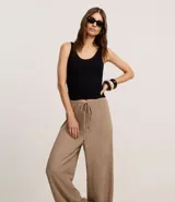 Pantalón wide leg color beige con textura, cintura elástica con cordón ajustable y bolsillos laterales.