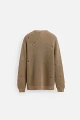 Sweater color marrón claro con efecto lavado ácido y roturas. De corte relajado, cuello redondo y mangas largas.