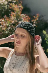 Gorro tipo casquette de crochet color beige con detalles dorados.