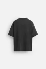 Camiseta negra de corte relaxed fit, cuello redondo y manga corta. Estampado frontal con texto en relieve a contraste. Efecto lavado.