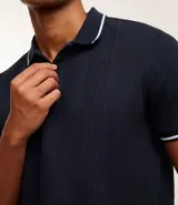 Chomba polo blanca de viscosa texturizada a rayas, corte regular, con cuello y mangas cortas en ribana con detalle contrastante en negro.