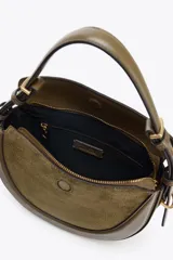 Bolso bandolera ovalado color verde oliva, con solapa de gamuza y asa de cuero ajustable.
