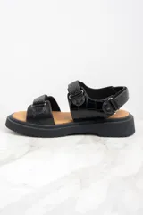 Sandalias negras con textura símil piel de cocodrilo, con ajuste de velcro y suela track.