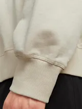 Buzo de manga larga y cuello redondo con fit holgado, confeccionado en tejido loop back sin cepillar 100% algodón.