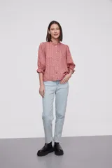 Blusa estampada con flores azules y hojas verdes, cuello mao con volados, mangas 3/4 con volados en los puños y cierre frontal con botones.