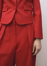 Pantalón de vestir rojo de corte wide leg, tiro alto, con detalle de pliegues, trabillas y forro interior.