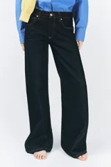 Jeans de tiro bajo con cintura con trabillas, cinco bolsillos, pespuntes marcados a contraste y pierna ancha.