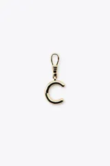 Dije dorado en forma de la letra A, con mosquetón para colgar en carteras o pulseras.