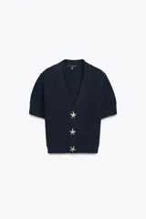 Chaqueta azul marino de punto con escote pico y manga corta. Cierre frontal con tres botones dorados en forma de estrella.