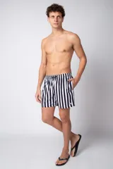 Short de baño para hombre con cintura elástica y cordón ajustable. Presenta un estampado de rayas verticales anchas en color verde oscuro y blanco. Incluye bolsillos laterales y un pequeño parche con logo en el bajo.