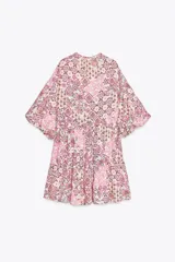 Vestido corto con estampado floral en tonos rosados, escote en pico y mangas abullonadas.
