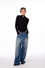 Jean oversized de tiro bajo, color azul lavado, con estampa BLKMBA grabada con láser en el frente y estampa worldwide en la parte trasera.