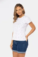 Remera blanca de algodón y poliéster con estampado de flores rojas pequeñas, cuello redondo y mangas cortas.