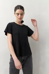 Remera blanca de manga corta con cuello redondo y costuras verticales en el frente.