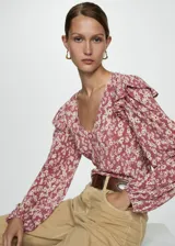 Blusa de manga larga con estampado floral en tonos rosa y blanco, escote en V, volantes en los hombros y puños elásticos.