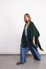 Ruana tejida en lana merino color amarillo pastel, con terminación de flecos.