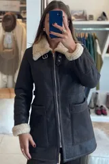 Campera marrón de cuero ovino con cuello y puños de piel sintética color crema, cierre frontal con cremallera y bolsillos laterales.