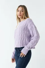 Sweater tejido con trama de ochos color fucsia, cuello redondo y corte cropped.