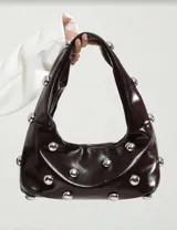 Bolso hobo verde militar con tachas plateadas, de tela suave y asa corta.