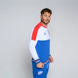 Buzo de cuello redondo Umbro del Club Nacional de Football, modelo Plaqueta CNdeF Oficial para hombre. Diseño con bloques de color azul marino, rojo y blanco. Incluye logo de Umbro y escudo del club en el pecho.