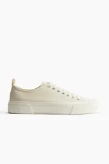 Championes de lona color crema con cordones y suela de goma.