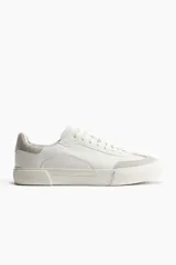 Championes deportivos blancos de estilo retro en tejido revestido con detalles en tejido cepillado gris. Collarín acolchado, lengüeta y cordones. Forro y plantillas de malla. Suelas de goma con diseño.