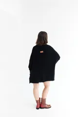 Poncho azul con cuello redondo y terminación desflecada.