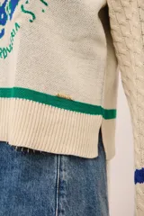 Sweater azul marino de punto con cuello redondo y mangas largas con diseño trenzado. Presenta un estampado de frutas y verduras con la inscripción "La verdulería S.A.".