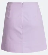 Minifalda evasé color lila de cuero sintético con bolsillos de parche y abertura lateral. Cierre trasero con cremallera.